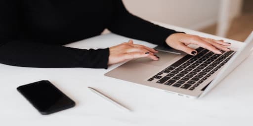 zdjęcie przedstawia terapeutkę prowadzącego sesję online przed komputerem
